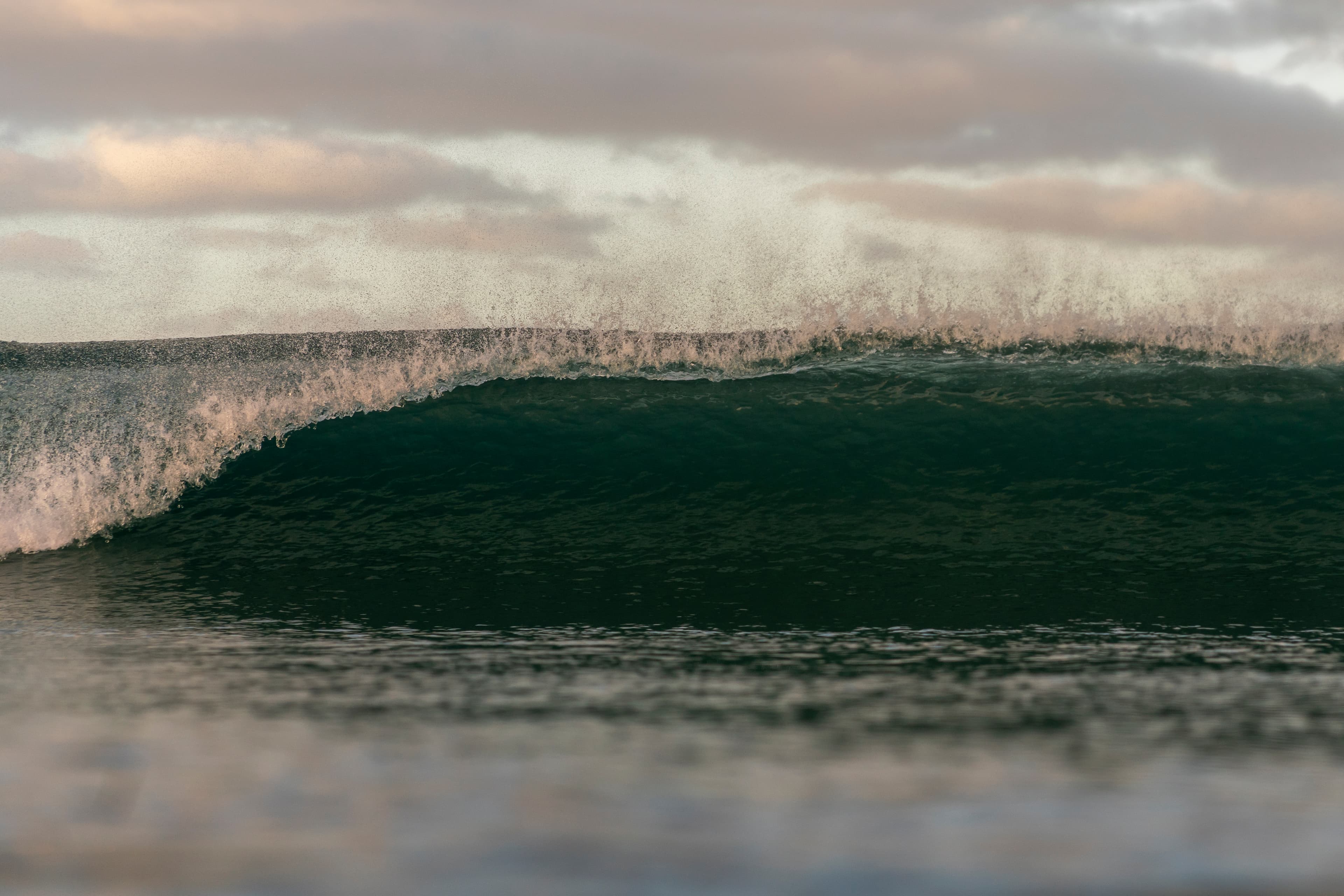 Teal barrel wave curling under a misty grey sky — fine art ocean photography print, Whangamata NZ.