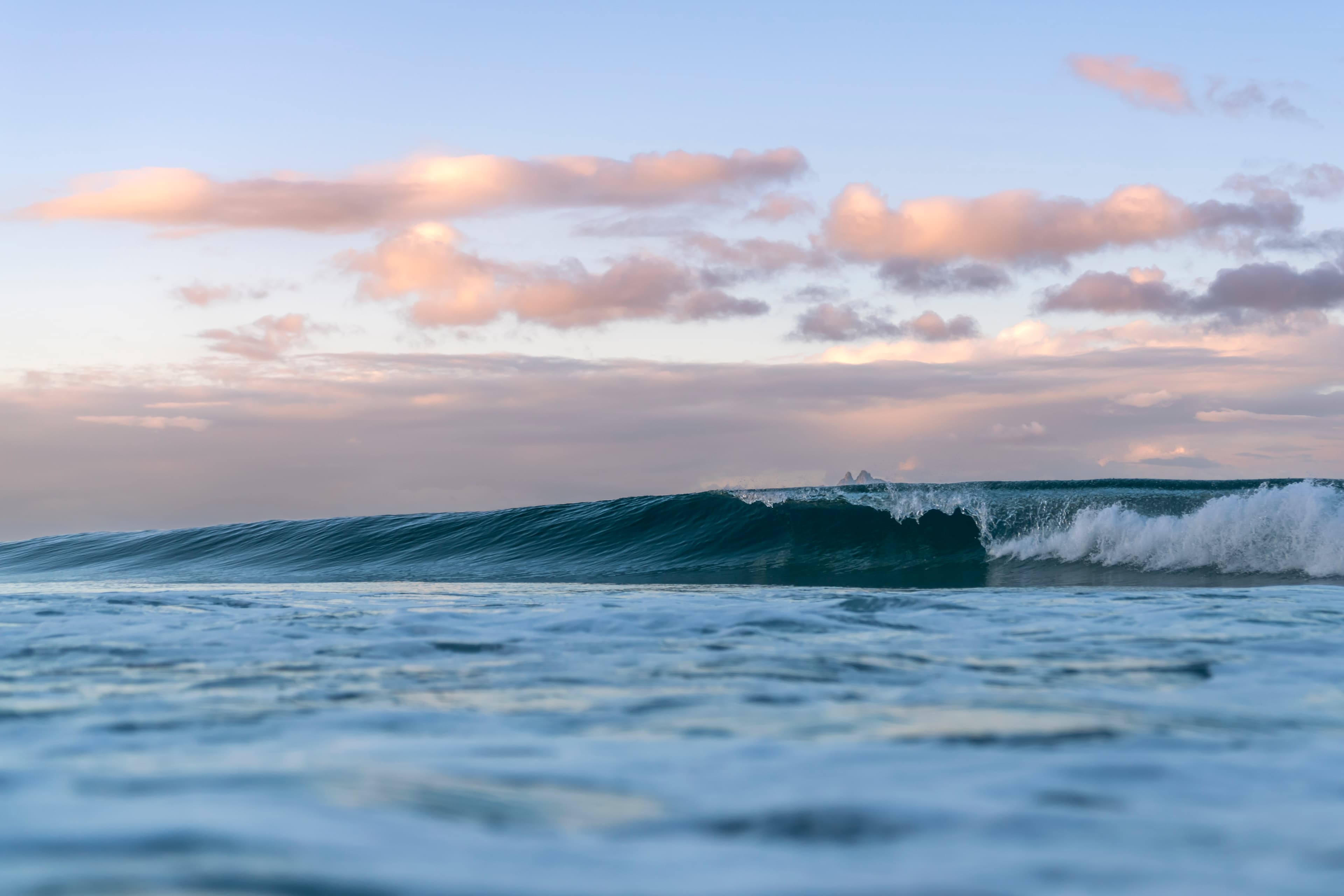 Gentle swell rolling under soft pastel clouds — fine art ocean photography print, Whangamata NZ.